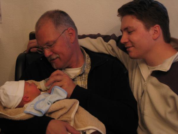 opa Herman geeft Merijn de fles en papa Boudewijn kijkt toe, geplaatst door papa Boudewijn op 2004-06-08